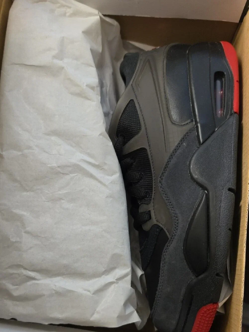 Air Jordan 4 RM Youth Athletic Shoe in Black with Red Accents 7Y
